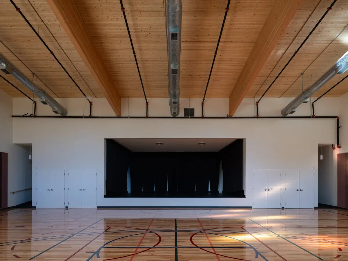 The gymnasium stage with its curtain drawn, cabinetry either side