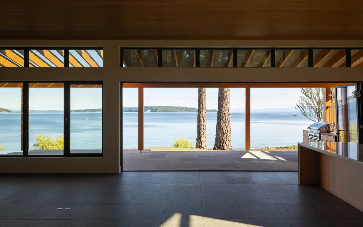 Living space opened to the terrace, two trunks and the water framed in the opening