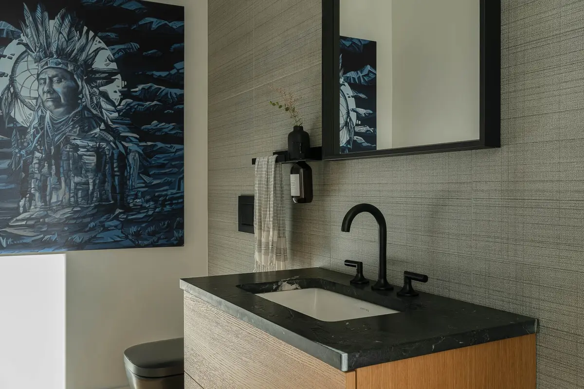Powder room with a dark stone counter on a wood vanity, a large painting alongside