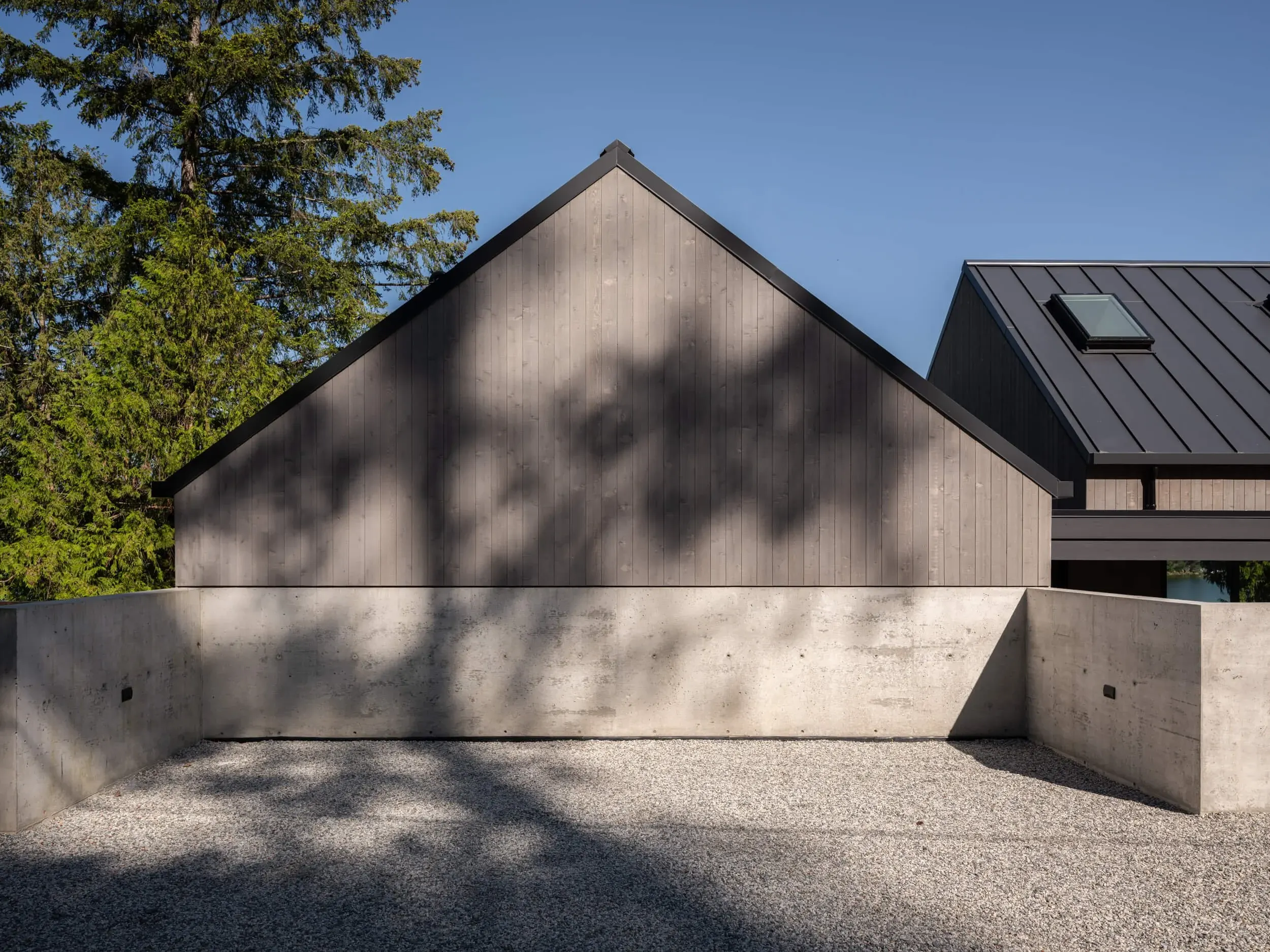 Johnstone Road blank gable over a concrete plinth with tree shadow
