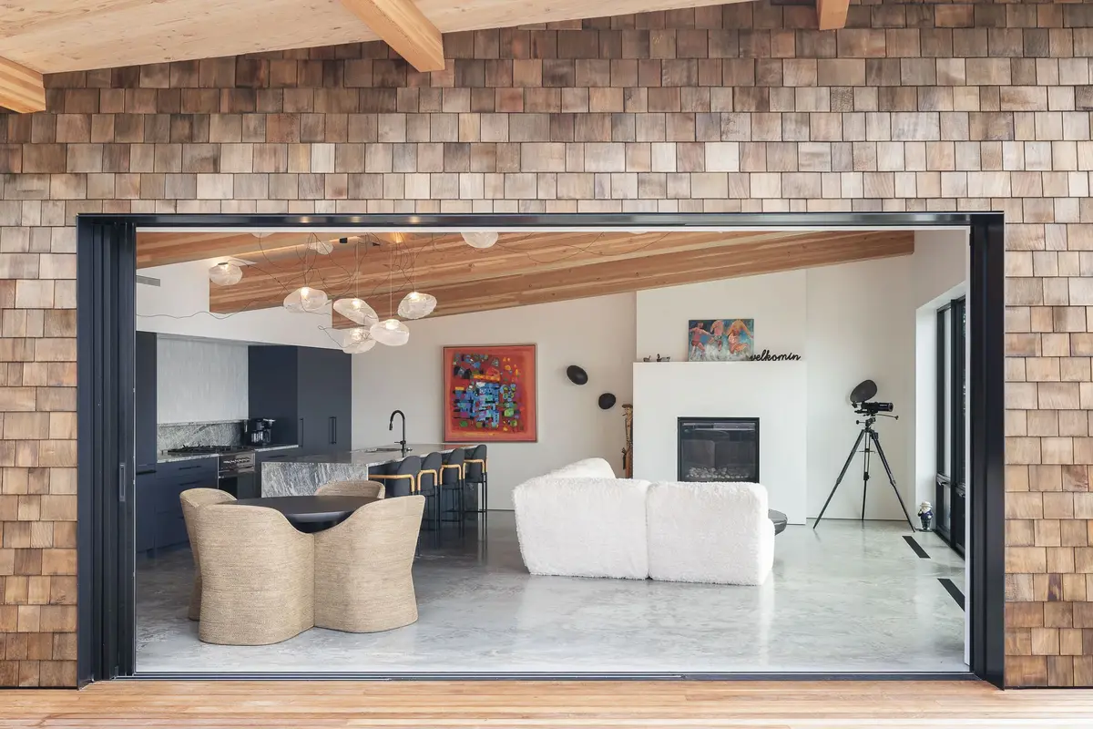 A sliding wall pulled fully open from the deck onto the kitchen, dining and living rooms