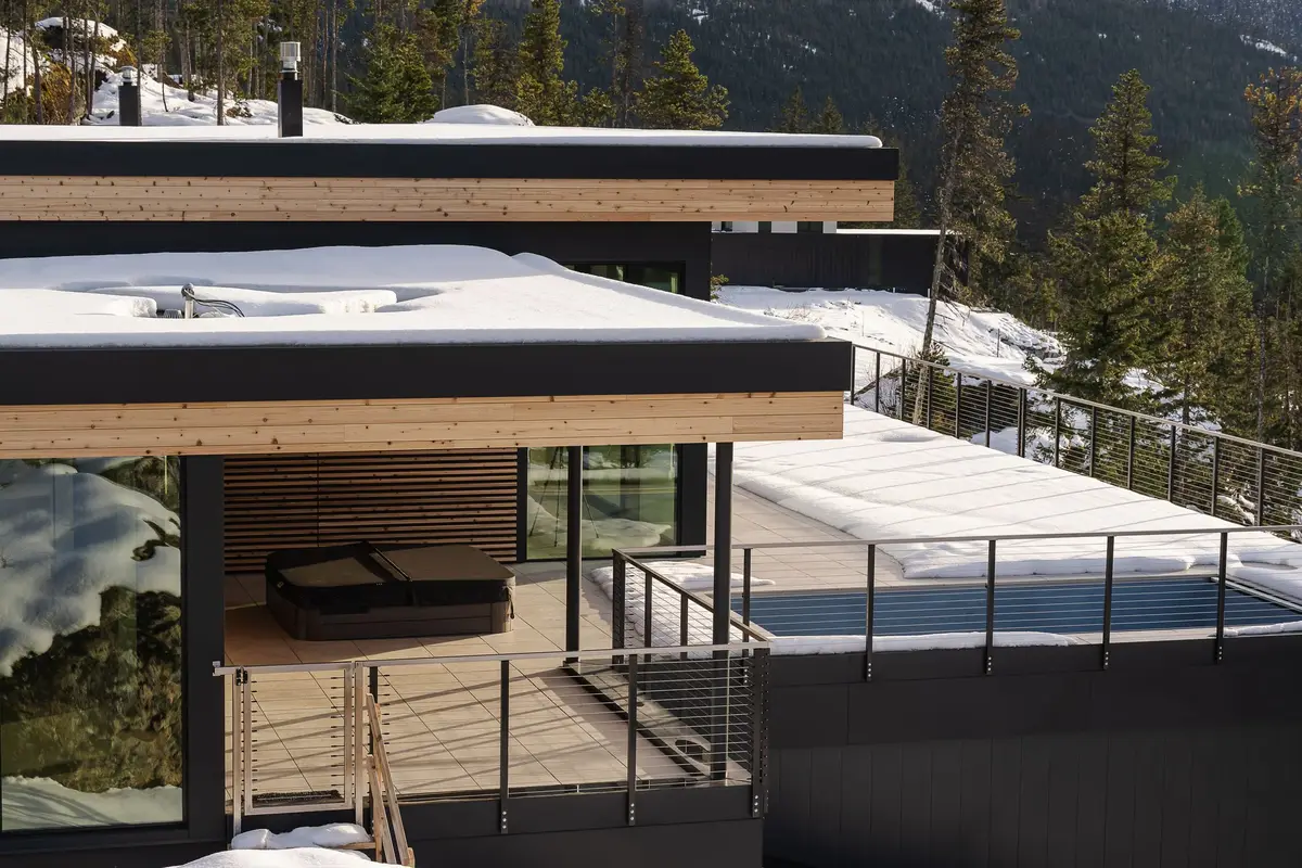 Roof terrace with a sunken hot tub under a deep overhang, snow across the deck