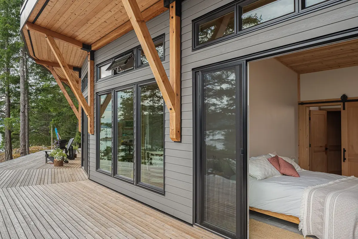 A sliding door open from the deck to a bedroom, wood braces along the wall
