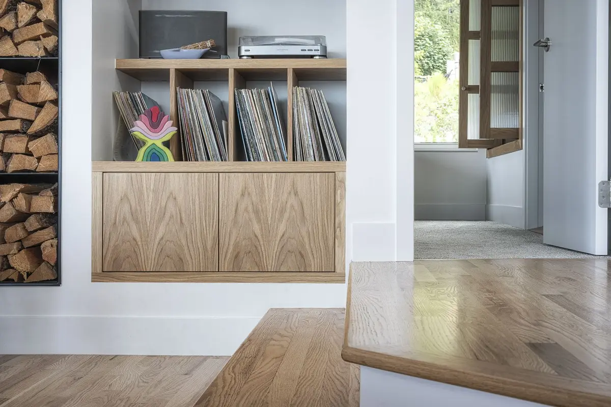 Built in cabinet and record shelf beside a firewood niche, a doorway through to another room