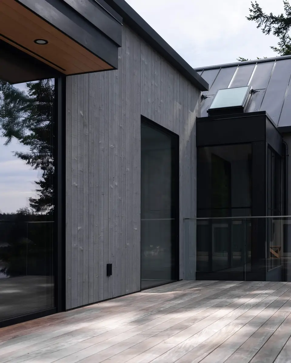 Grey board wall with a tall sliding door meeting a dark glazed corner off the deck