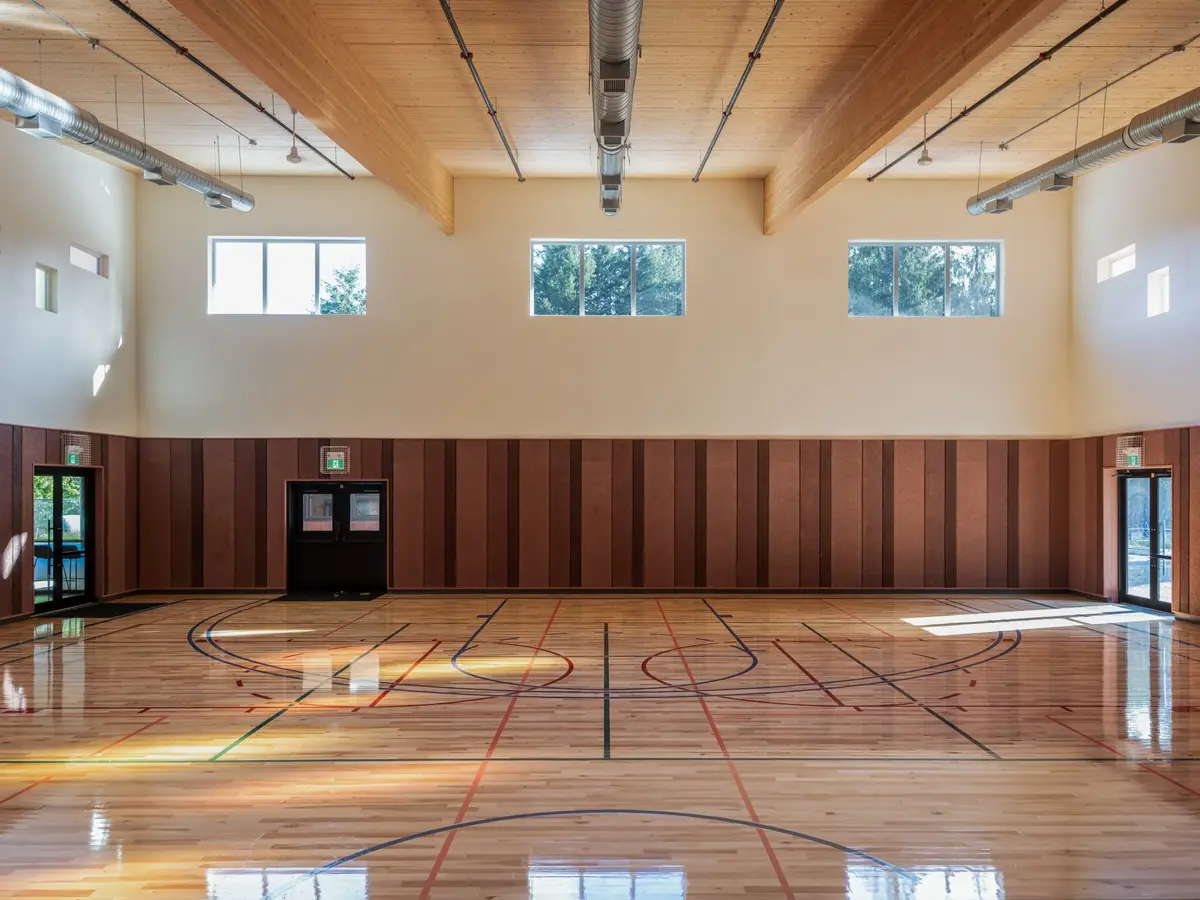 The gymnasium with clerestory windows along one side, court lines across the floor