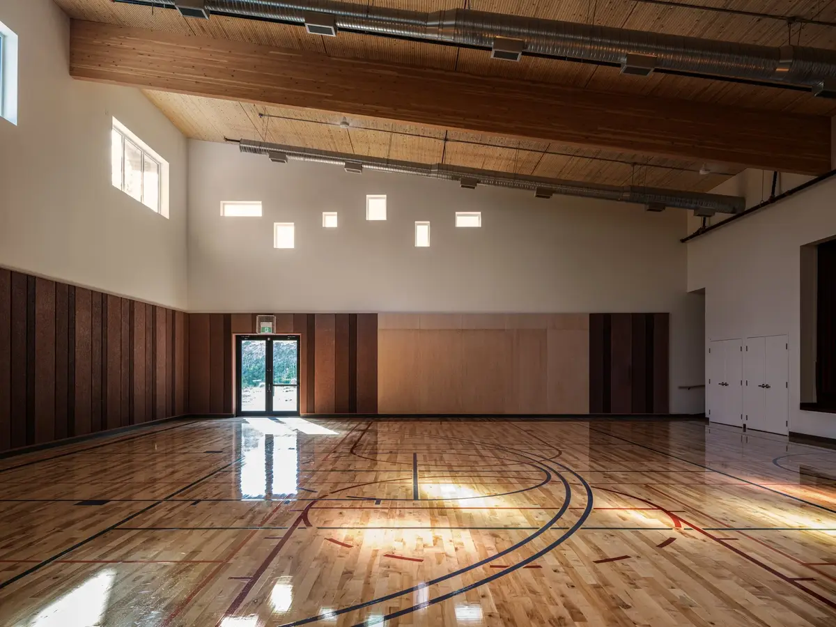 The gymnasium looking to the far corner, clerestory light falling across the floor