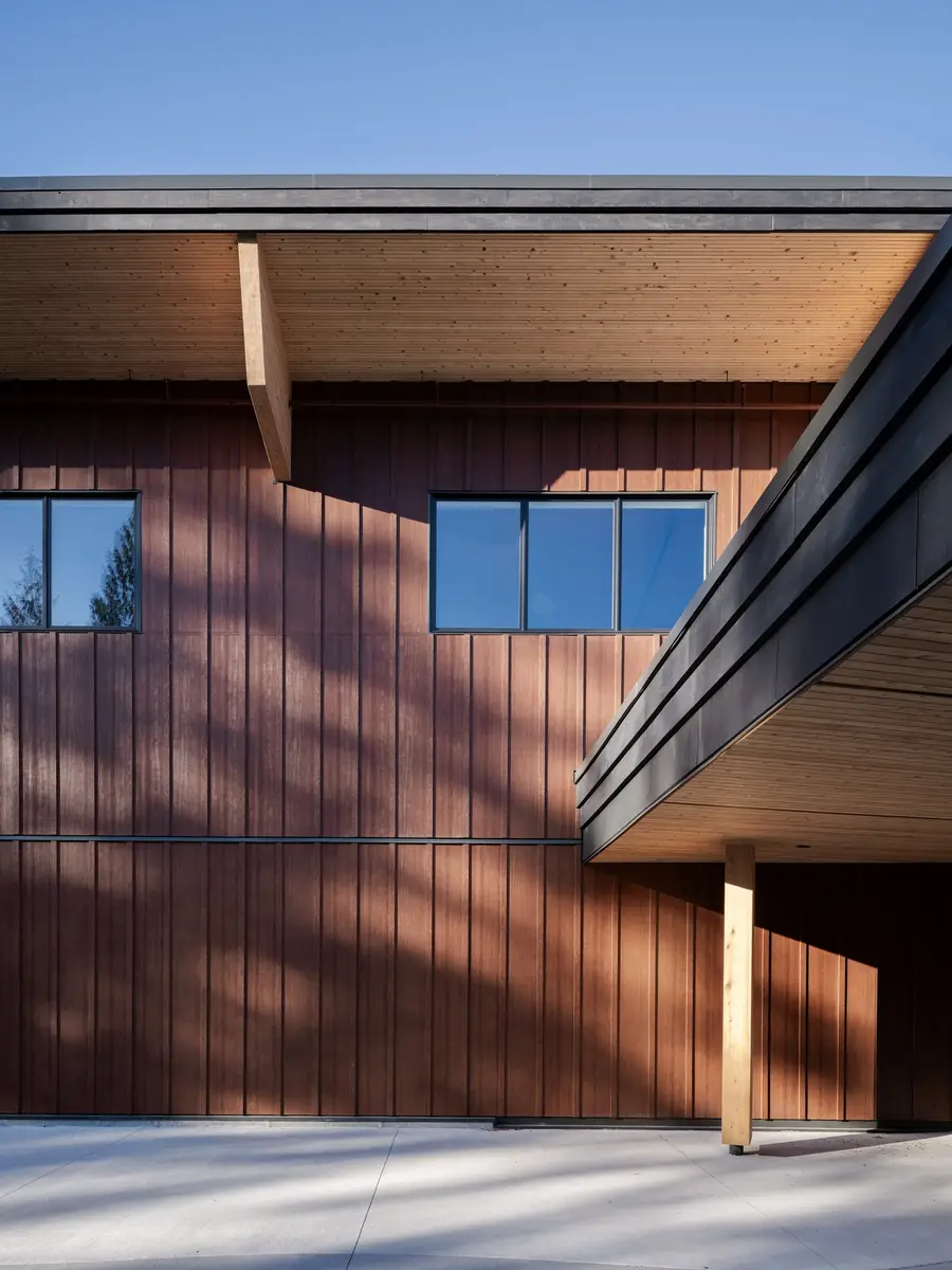 Roof planes meeting above vertical cladding, a timber column carrying the overhang