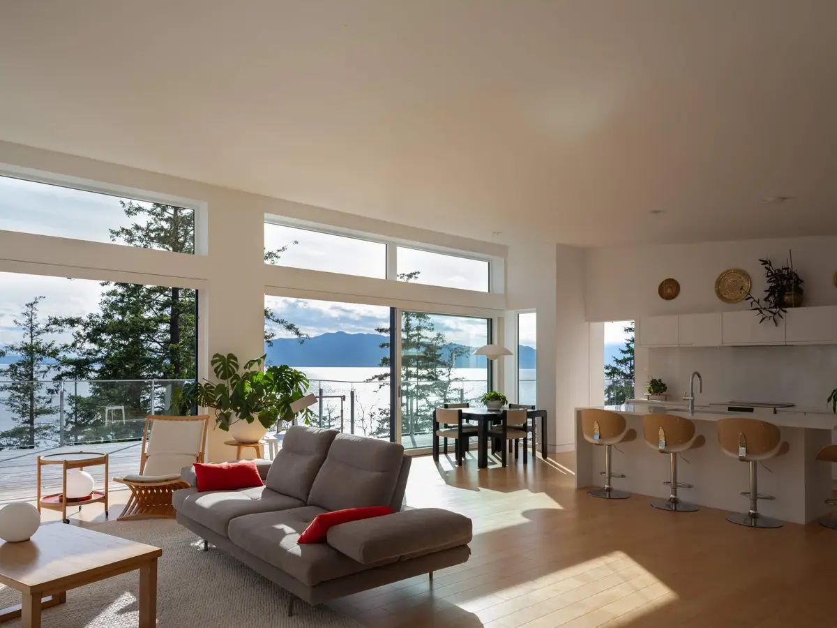 Open plan living, dining and kitchen in one room, glass to the deck and water