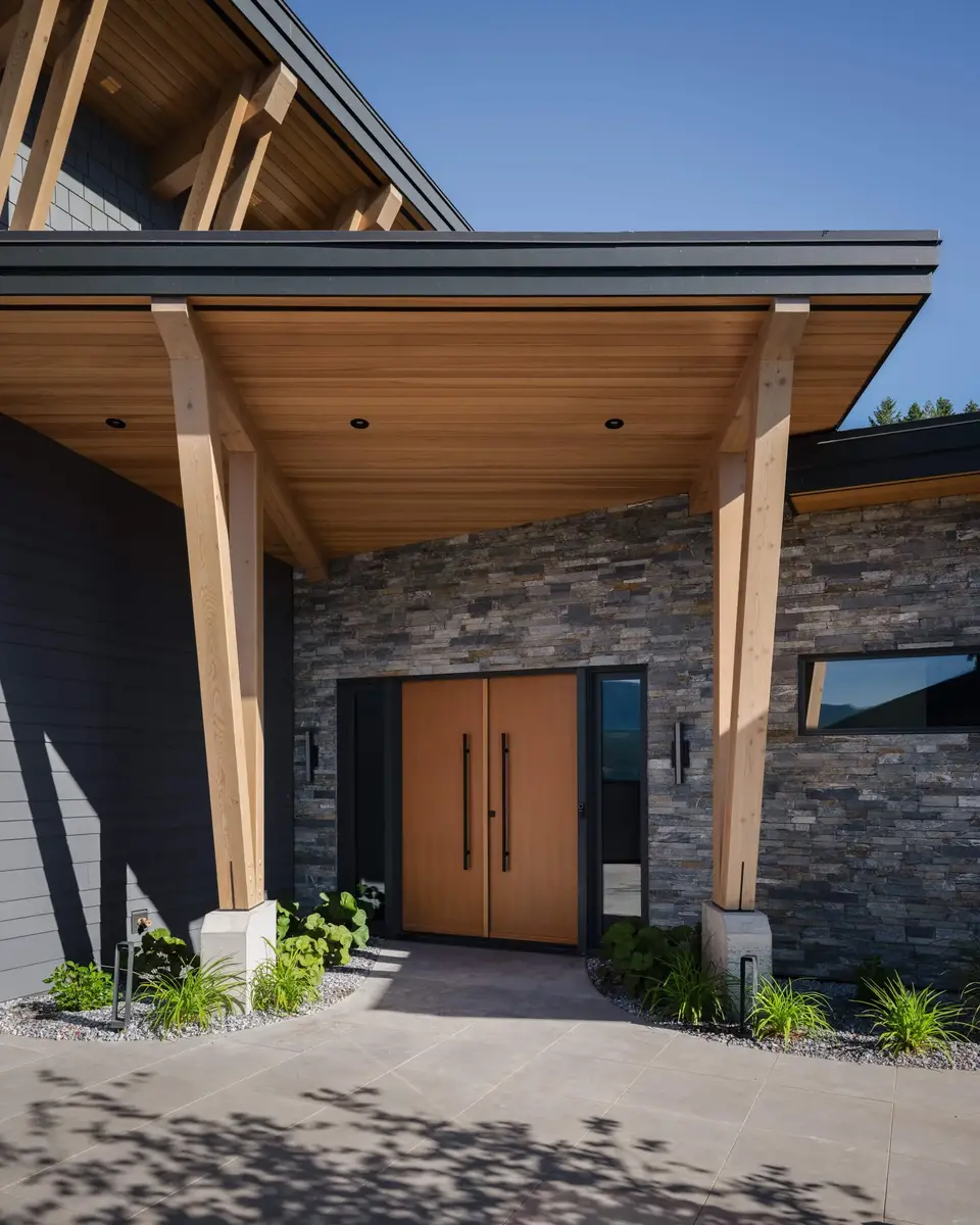 Covered entry porch on timber posts, wood doors in a stone wall under a deep soffit