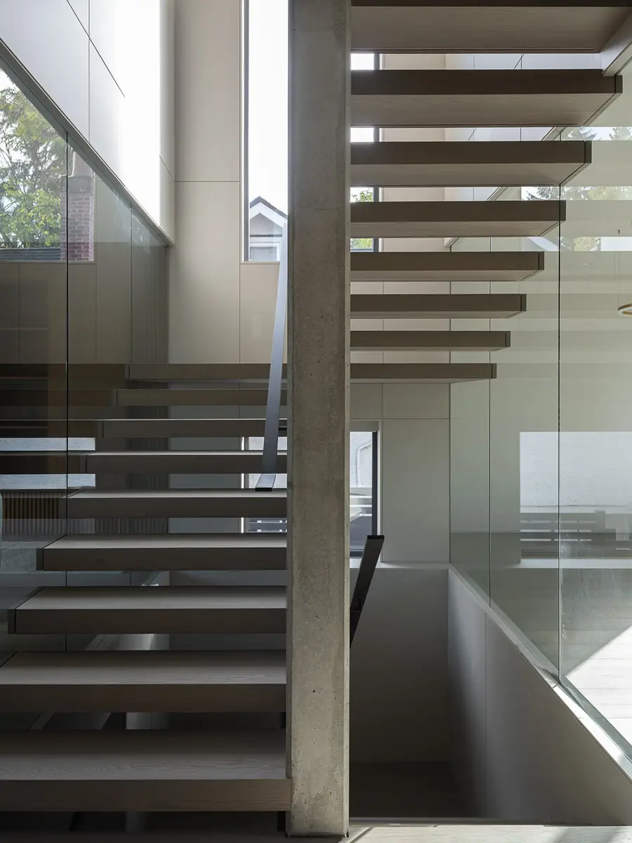 Treads and stringer from below, the concrete wall and glass balustrade above