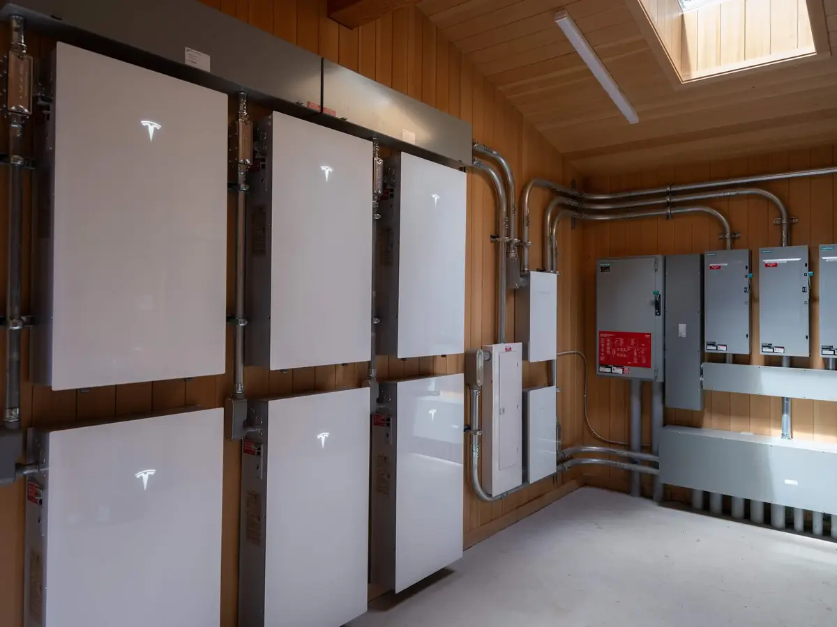Battery units and electrical panels along a wood lined room lit by a skylight