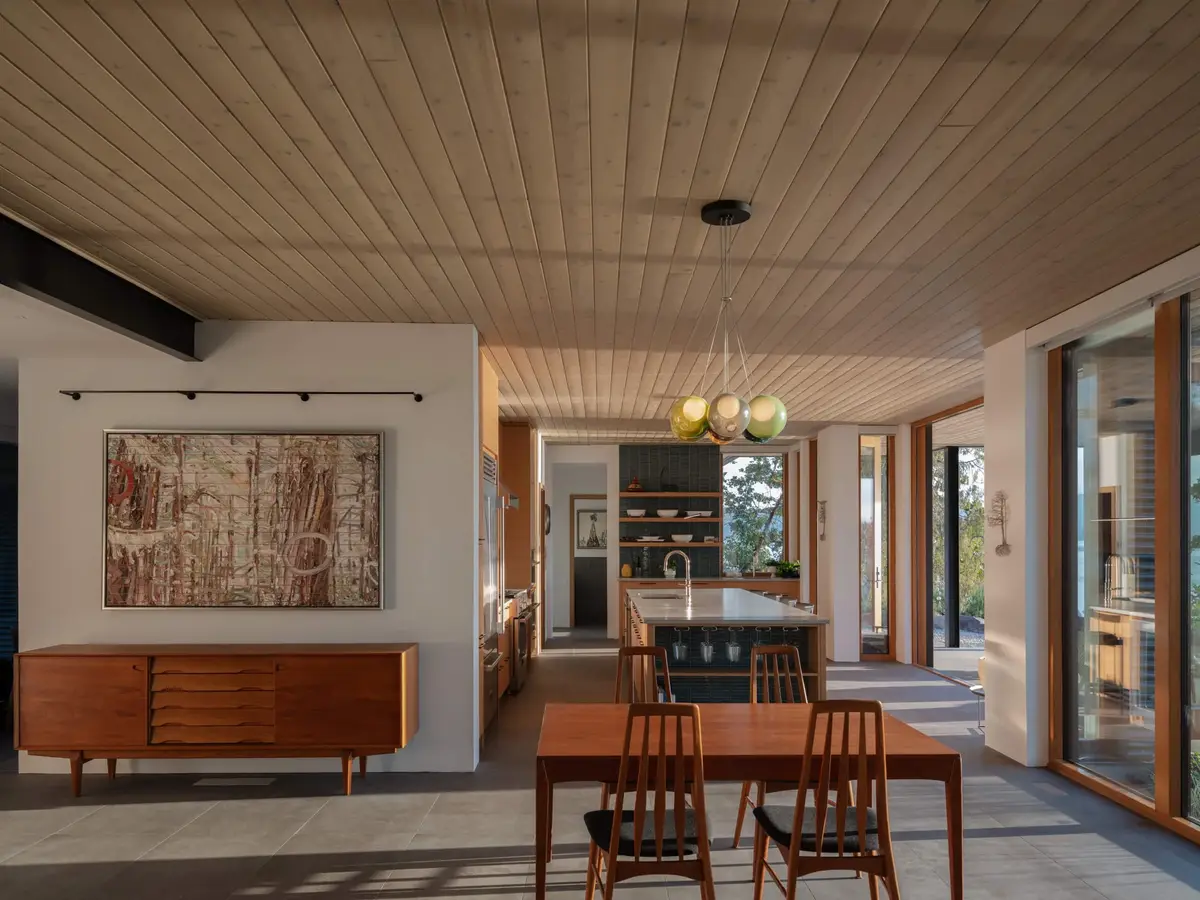 Dining room with a low wood sideboard below a large framed work