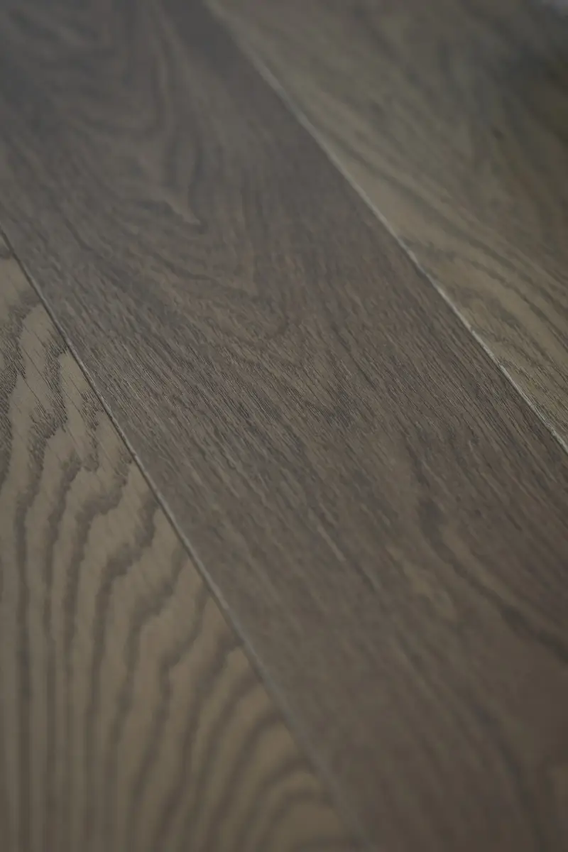 Wide floor boards running diagonally, the grain lit across the joints