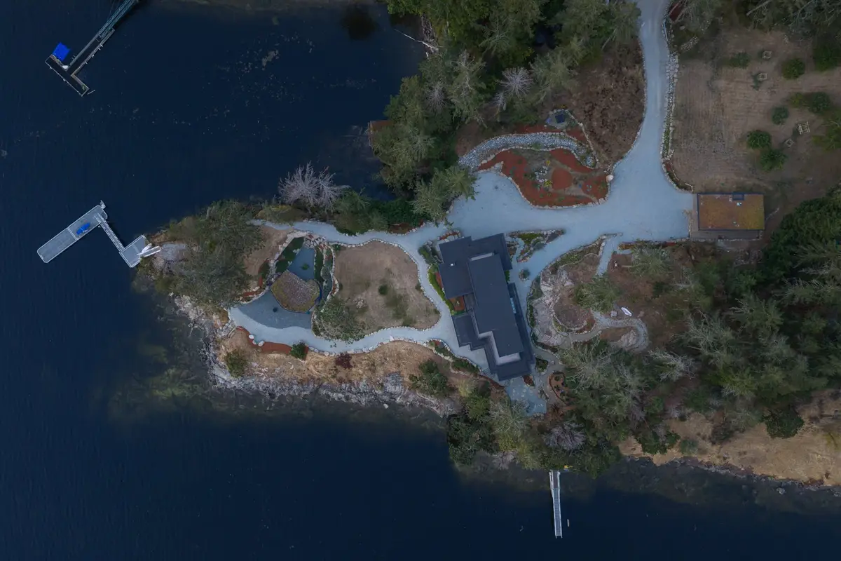 Aerial directly above the property, the house and its paths on a wooded point