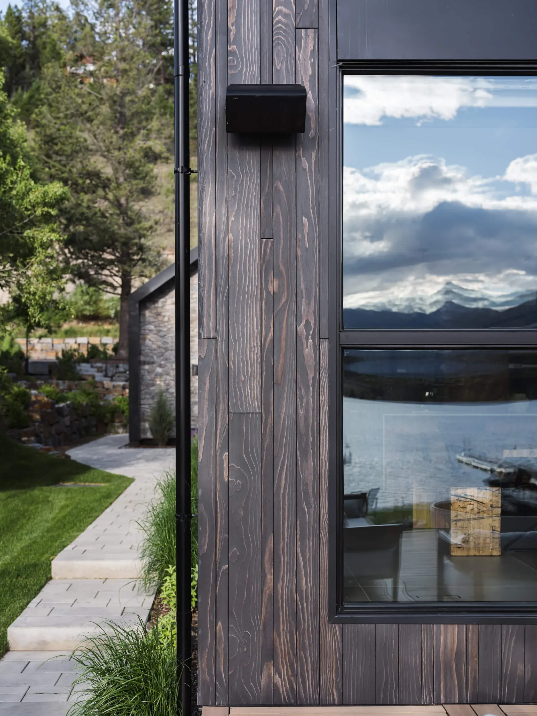 Coleman Residence charred cedar cladding reflecting the lake