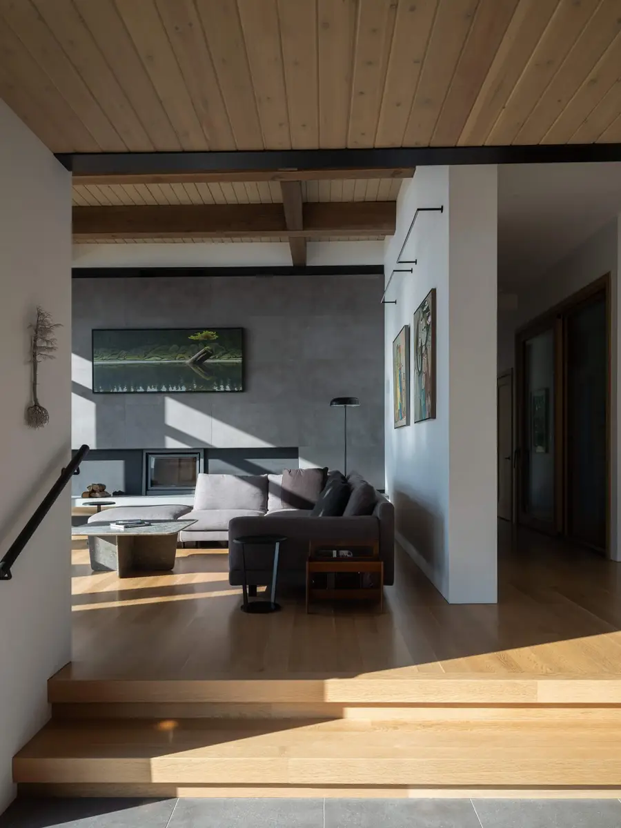 Living room seen from the entry steps, a grey fireplace wall beneath a wood ceiling