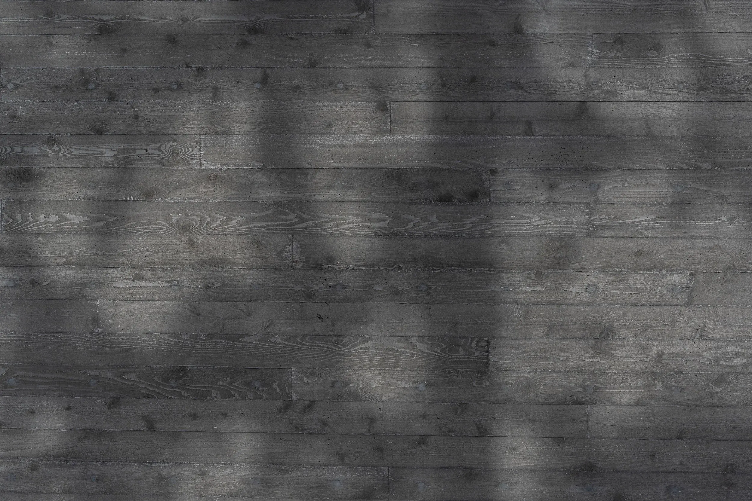 Dark stained horizontal siding in raking light, branch shadows across the boards