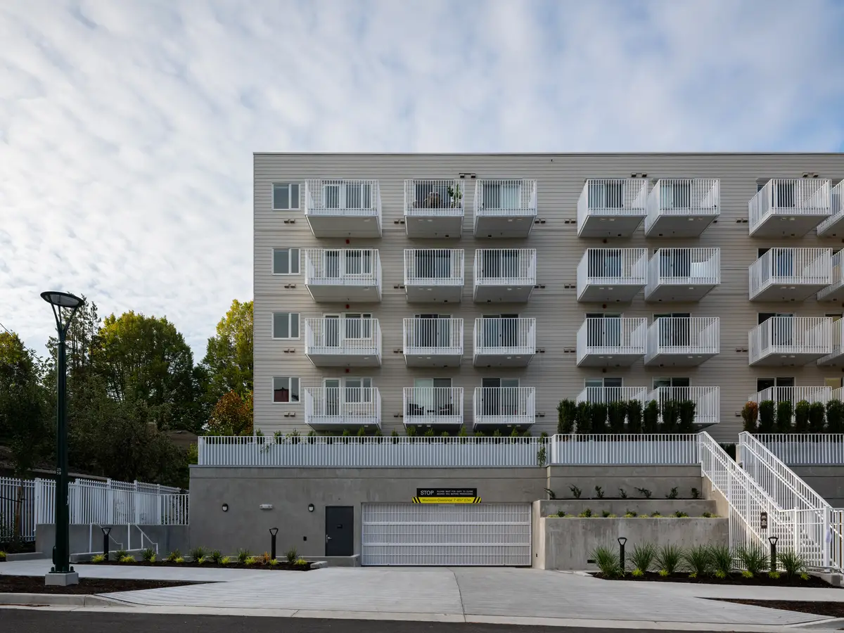 The front elevation head on, stacked balconies, an open stair and the garage below