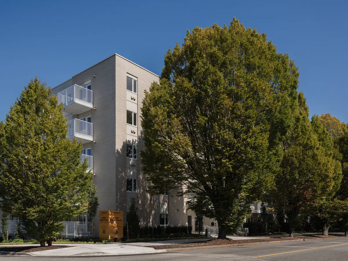 The street elevation seen through mature trees