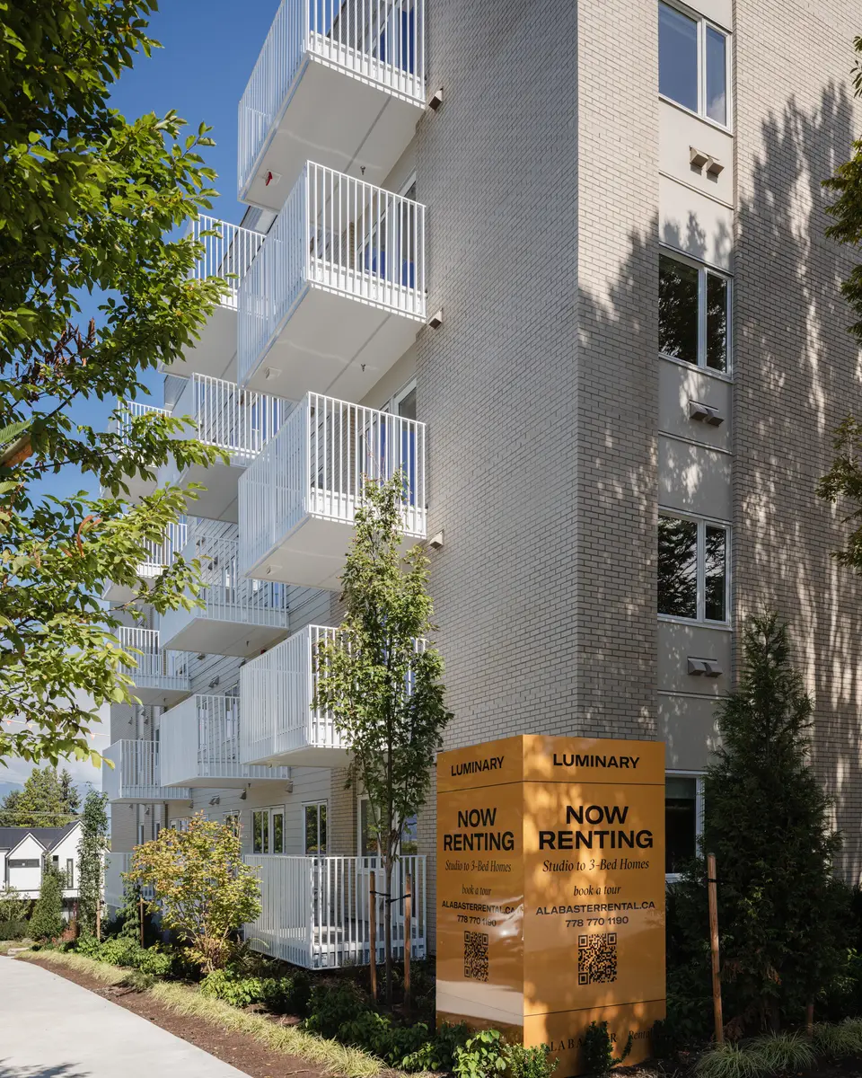 Balconies and a tree beside the leasing sign