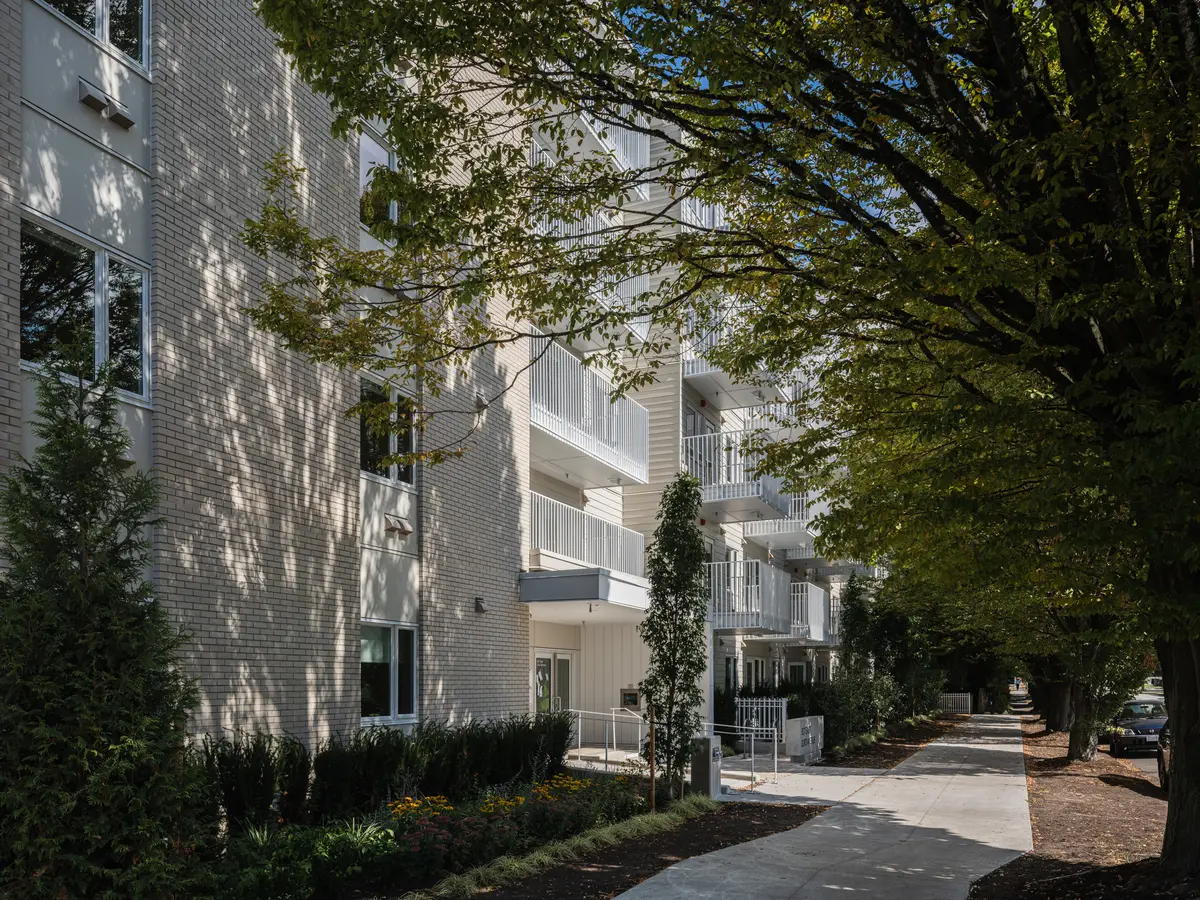 A curved path under trees toward the entry