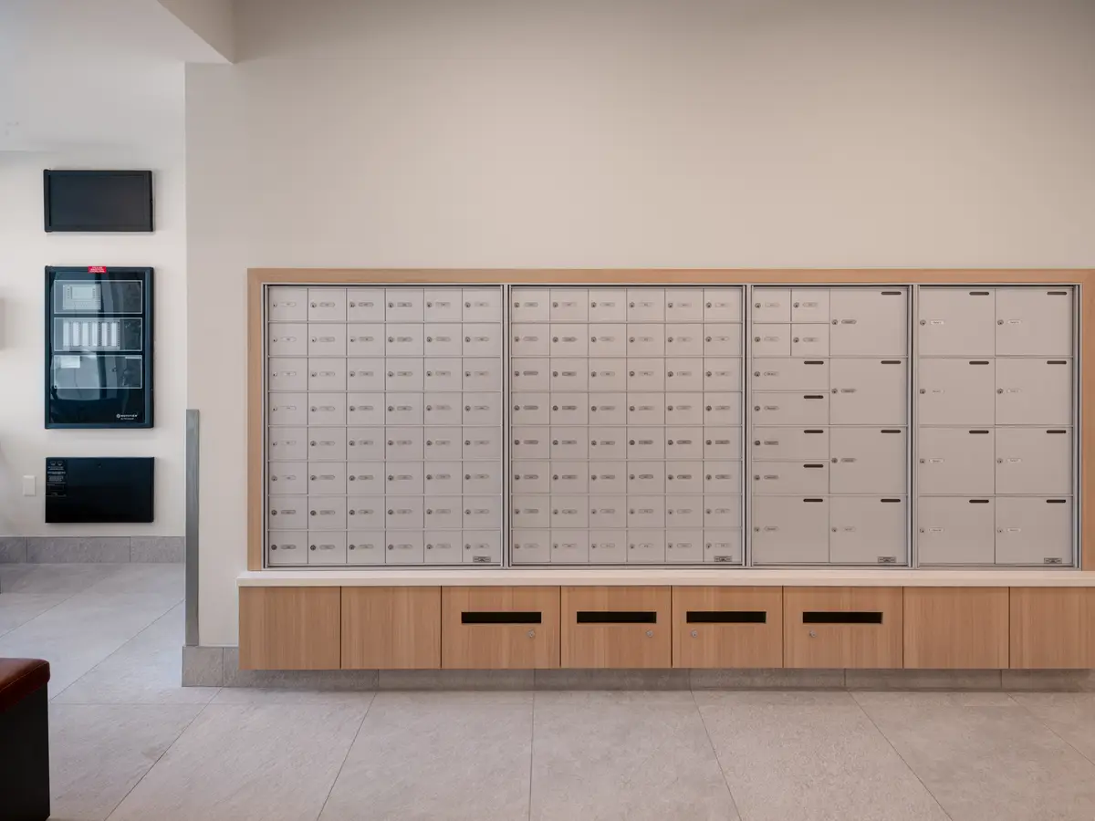 A wall of mailboxes in a wood cabinet