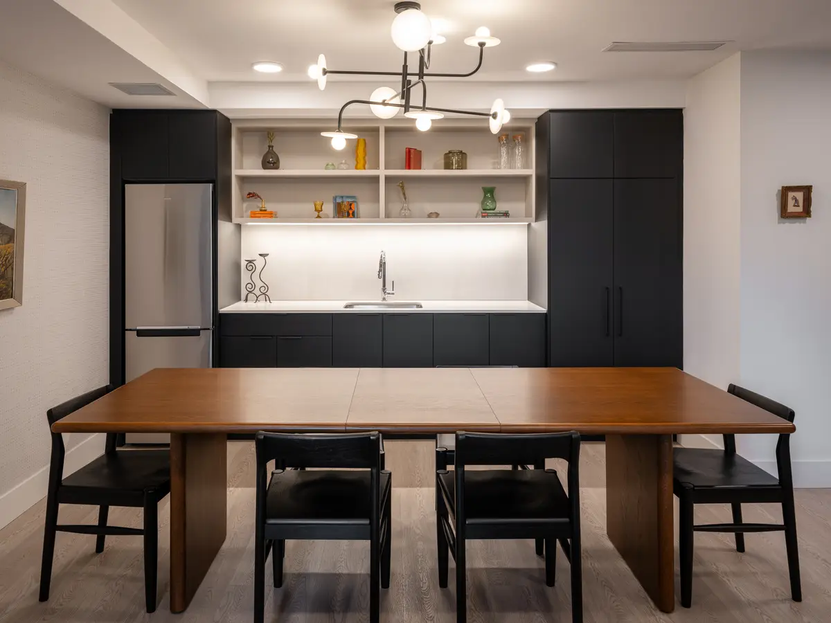 A wood dining table in front of the kitchen