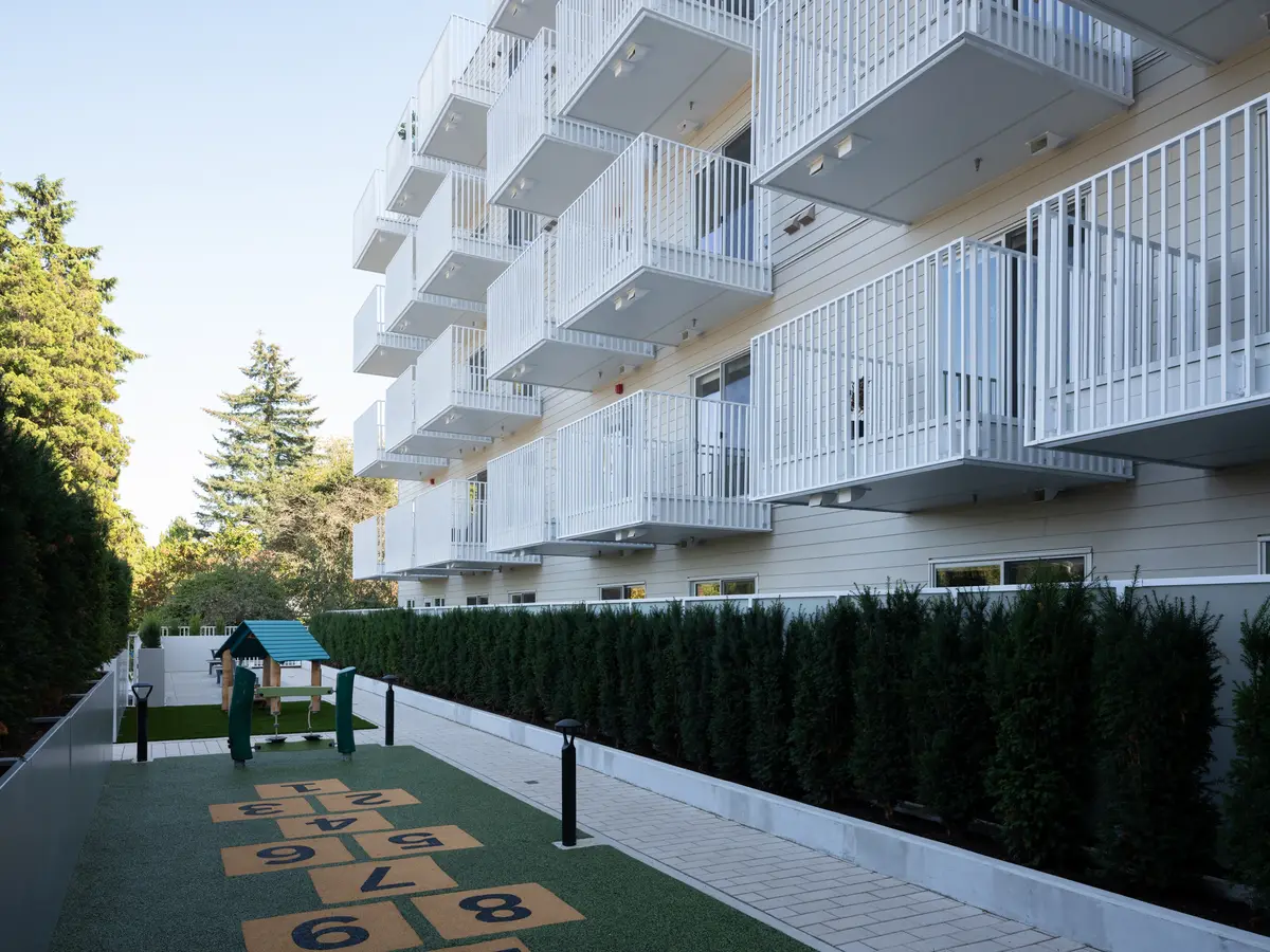 A play lawn and painted court beside the building