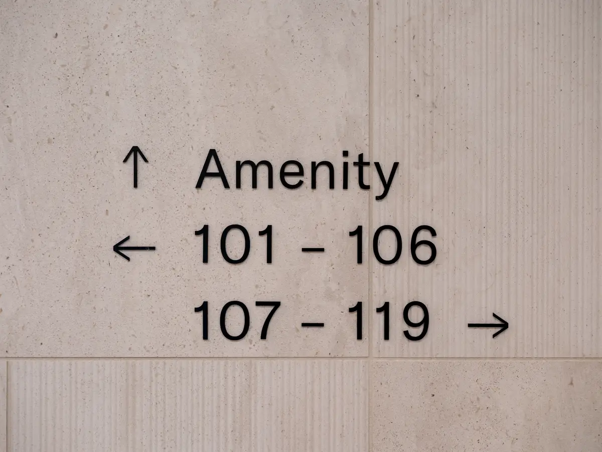 A concrete sign pointing to the amenity and the suite numbers