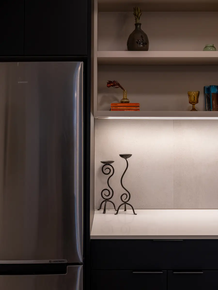 The refrigerator beside an open shelf