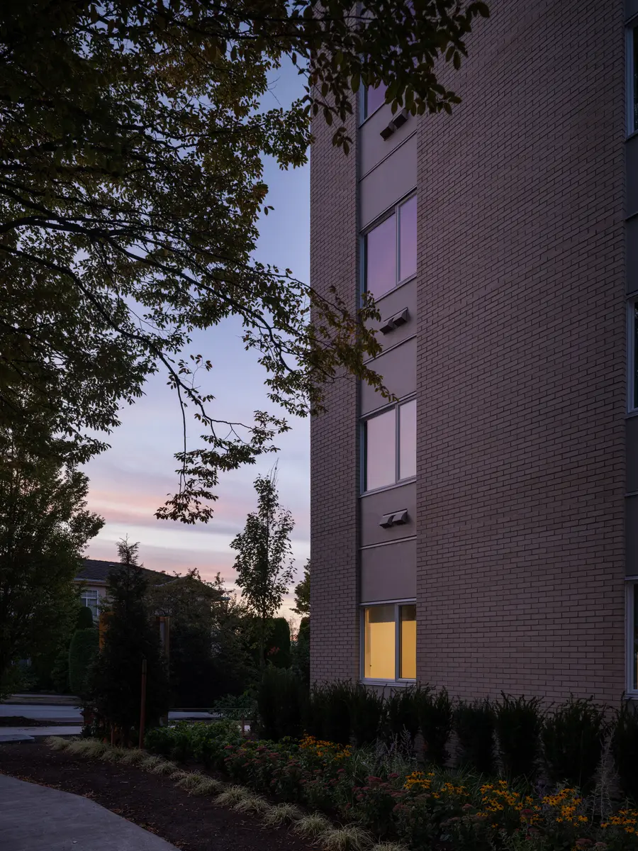 The brick corner at dusk, planting along the base
