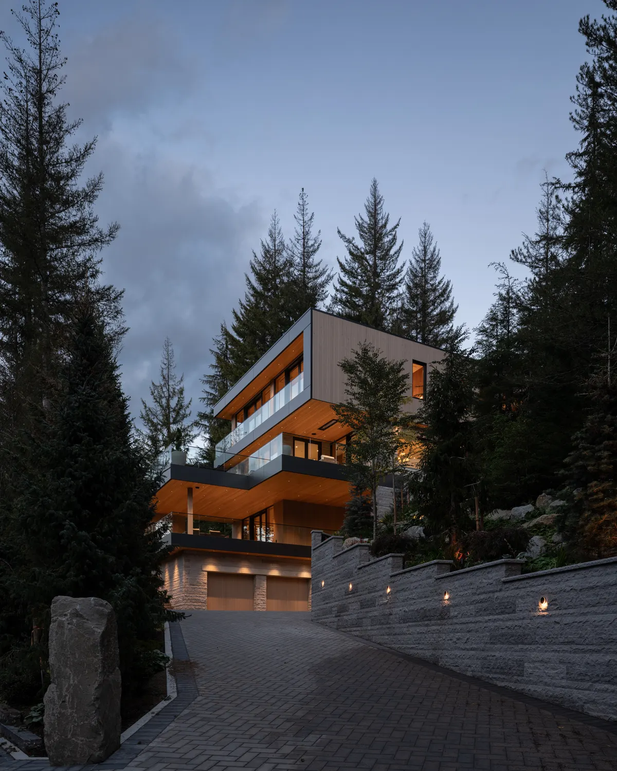 The drive at dusk, the house above a stone wall, Panorama Ridge, Whistler