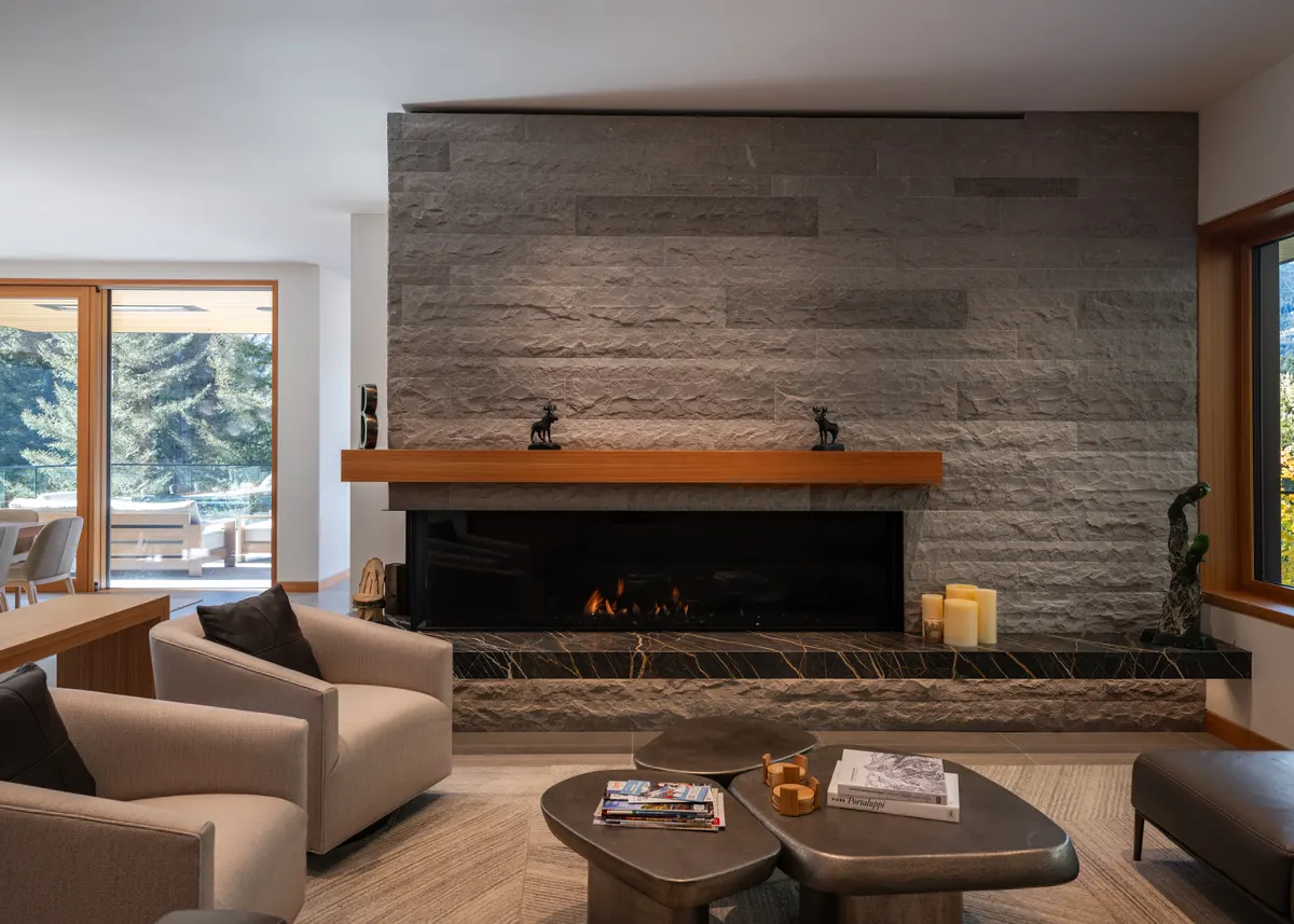 A stone fireplace, a wood mantel, and chairs in the living room, Panorama Ridge, Whistler