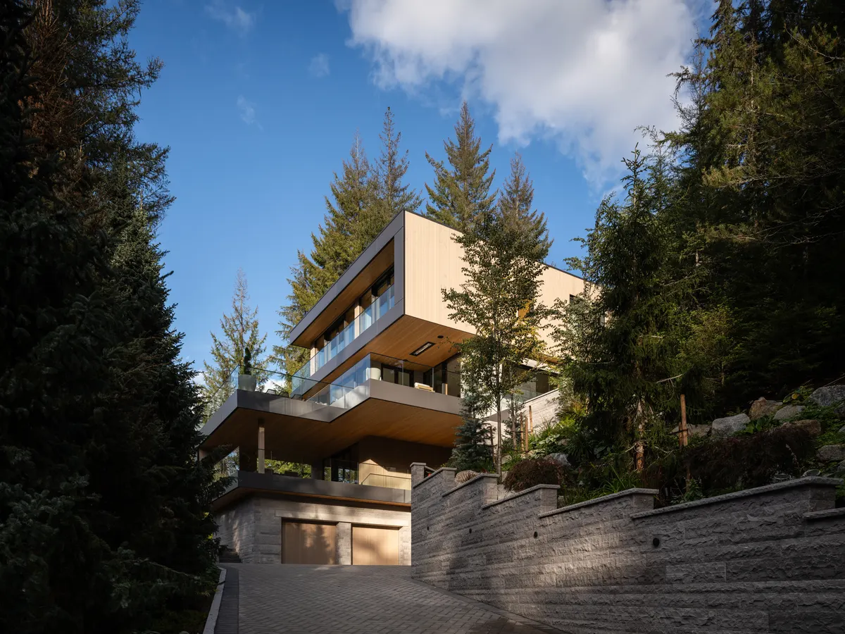 The house from below, wood volumes over a stone base, Panorama Ridge, Whistler