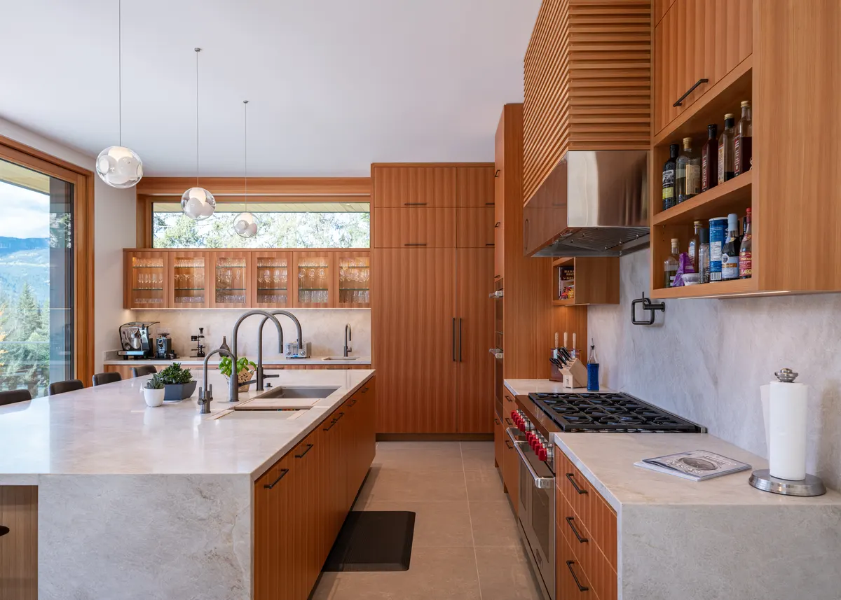 The kitchen, a stone island and wood cabinets, windows to the valley, Panorama Ridge, Whistler