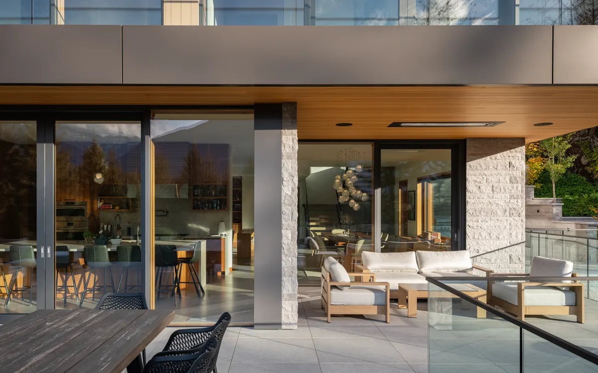 Lounge seating on the terrace, the kitchen visible through the glass, Panorama Ridge, Whistler