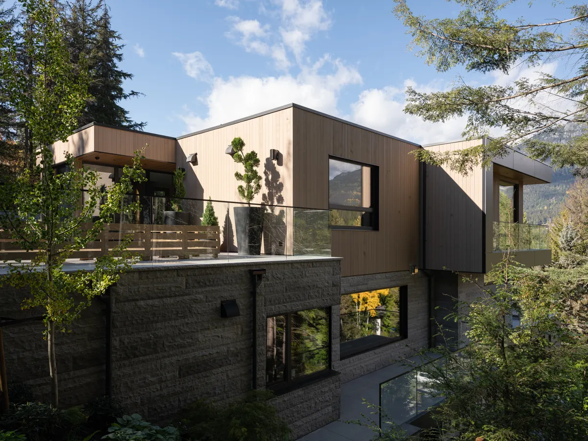 The side of the house, wood above a stone base, among the trees, Panorama Ridge, Whistler