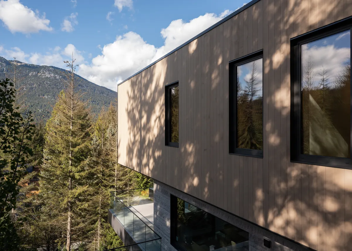 The wood-clad volume and black windows, firs and the mountain beyond, Panorama Ridge, Whistler