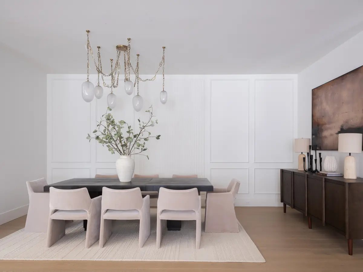 A long dining table under a chandelier