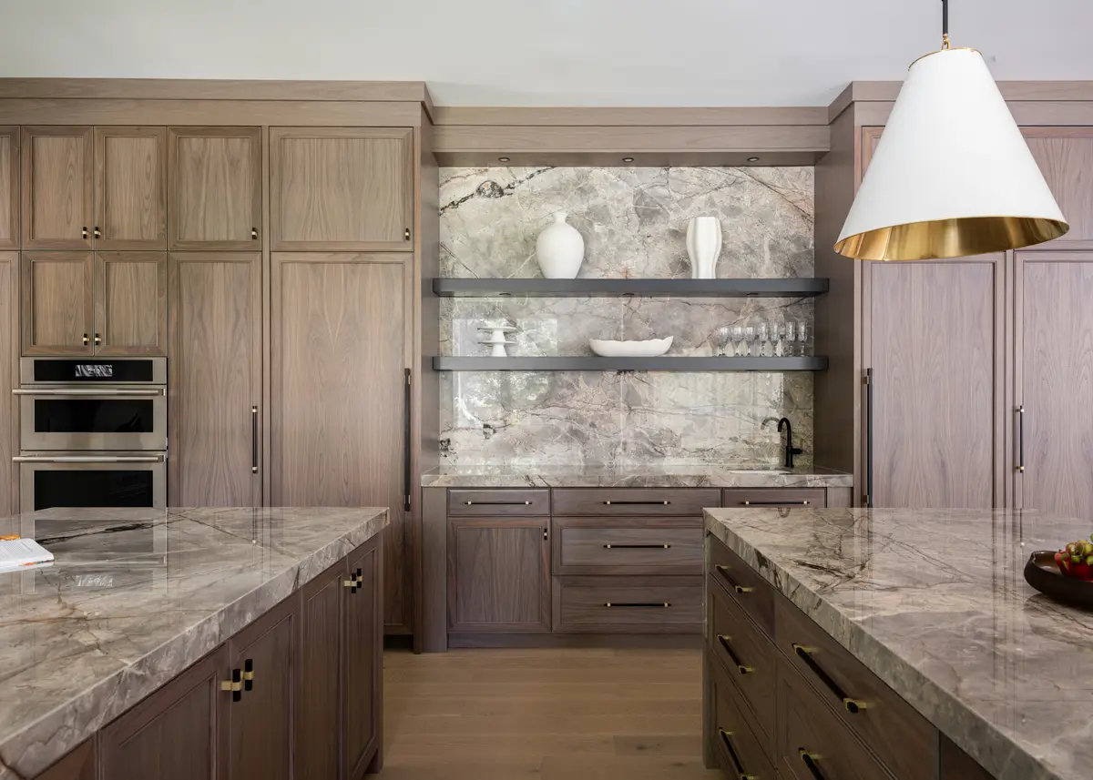 The kitchen counter, wood cabinets and a stone backsplash