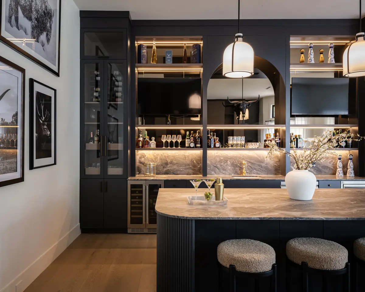 A black bar with lit shelves and stools