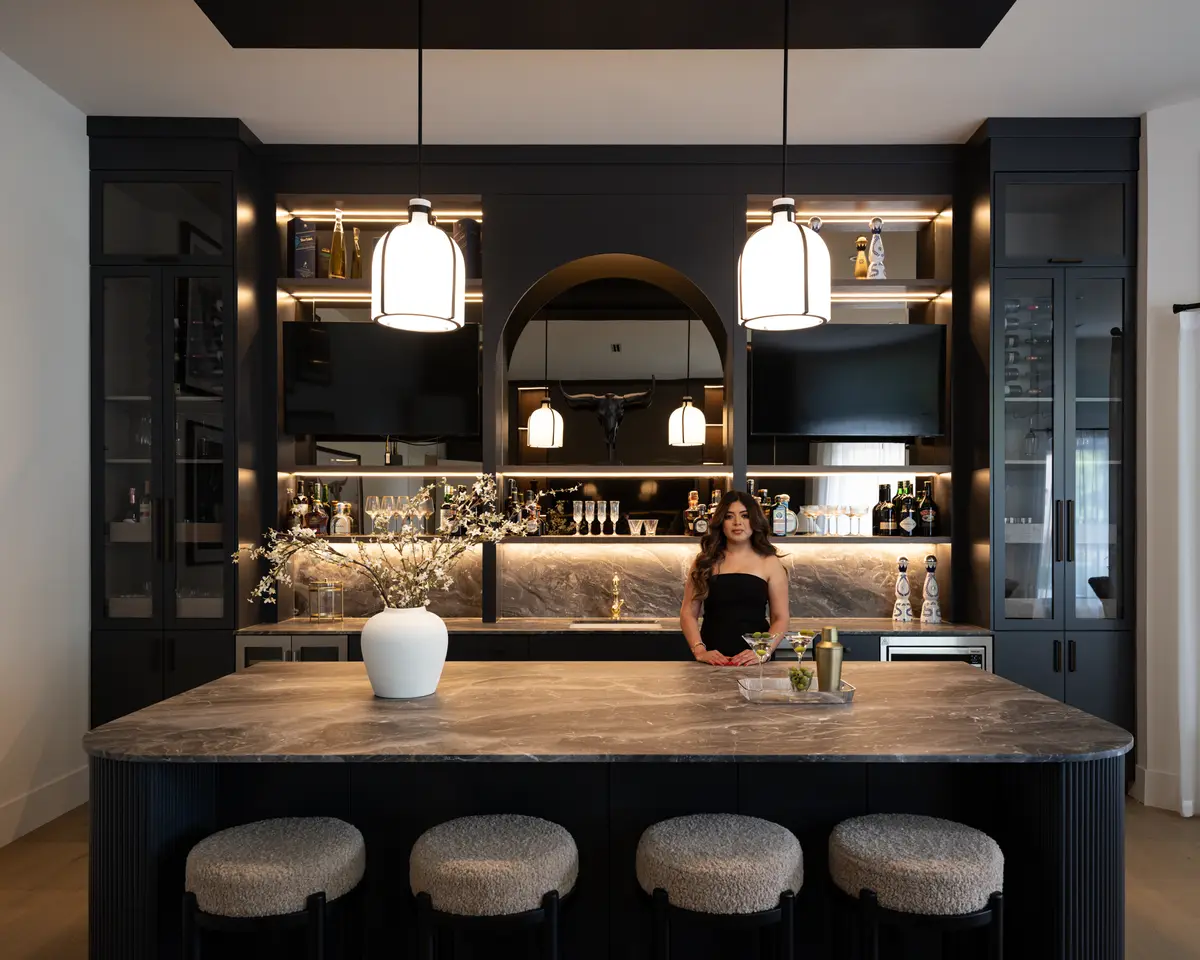 The bar, lit shelves, and a row of stools