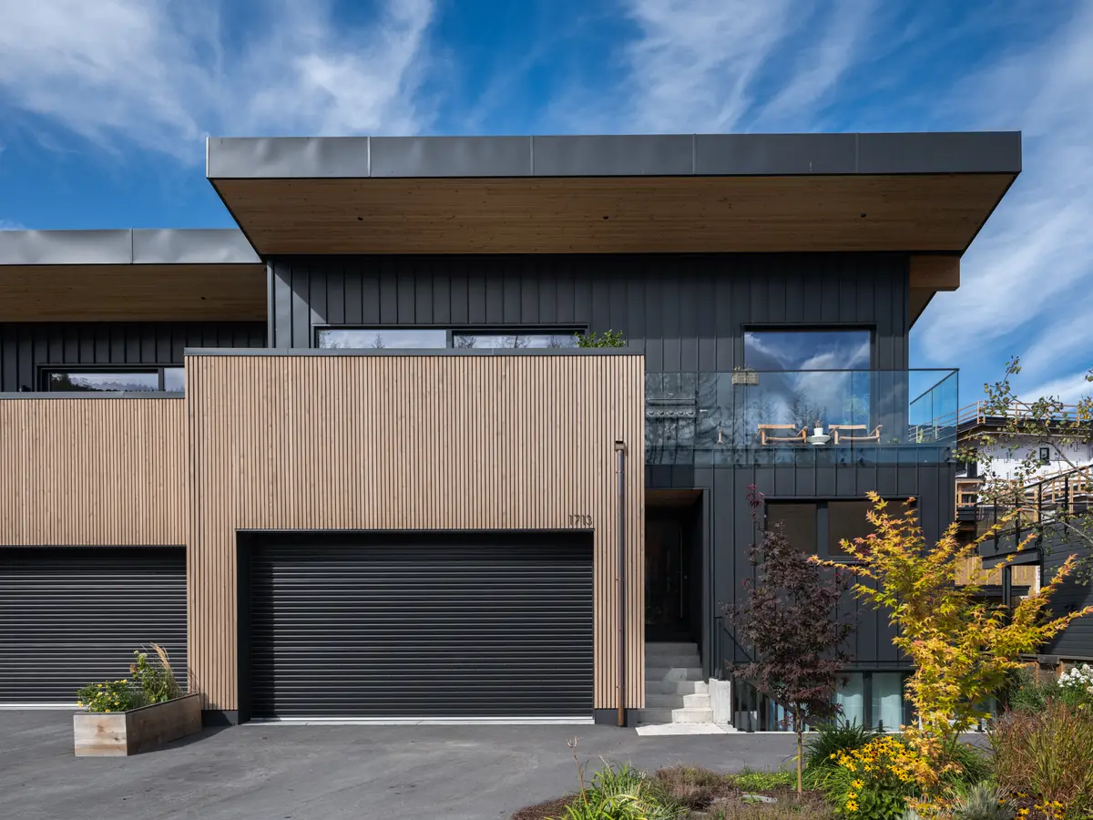 Front of the house and the roll-up garage door at Riverrun Place, Whistler, vertical wood and black metal