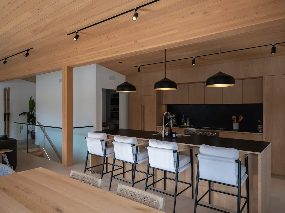 Kitchen island with stools under a wood ceiling at Riverrun Place, Whistler