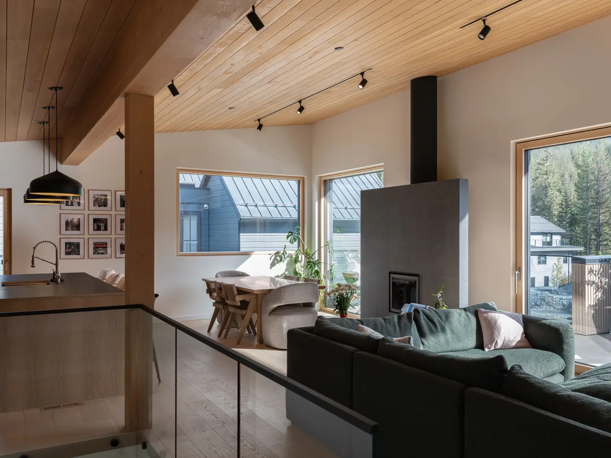 Living room toward the windows, a dark fireplace and forest beyond, Riverrun Place, Whistler