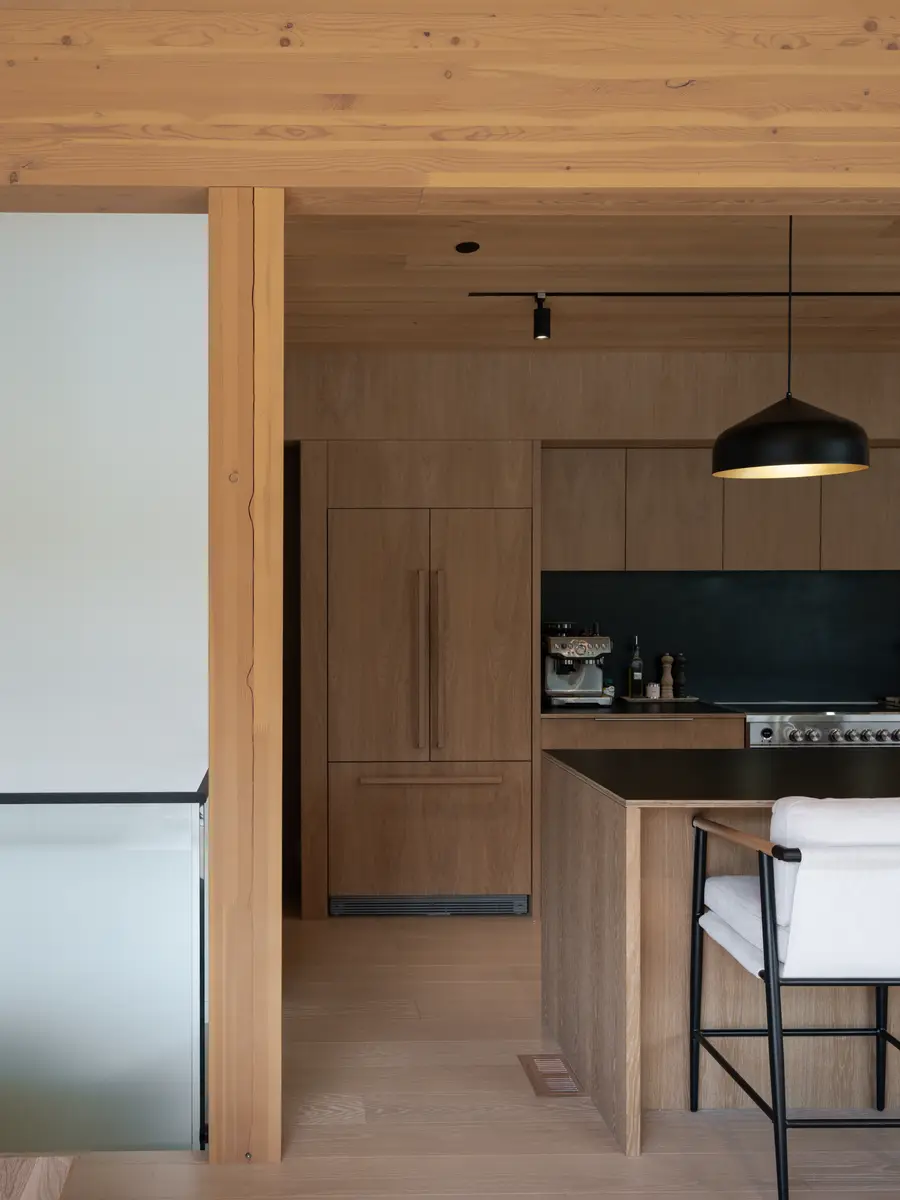 Panelled fridge in the wood millwork, an espresso machine on the counter, Riverrun Place, Whistler
