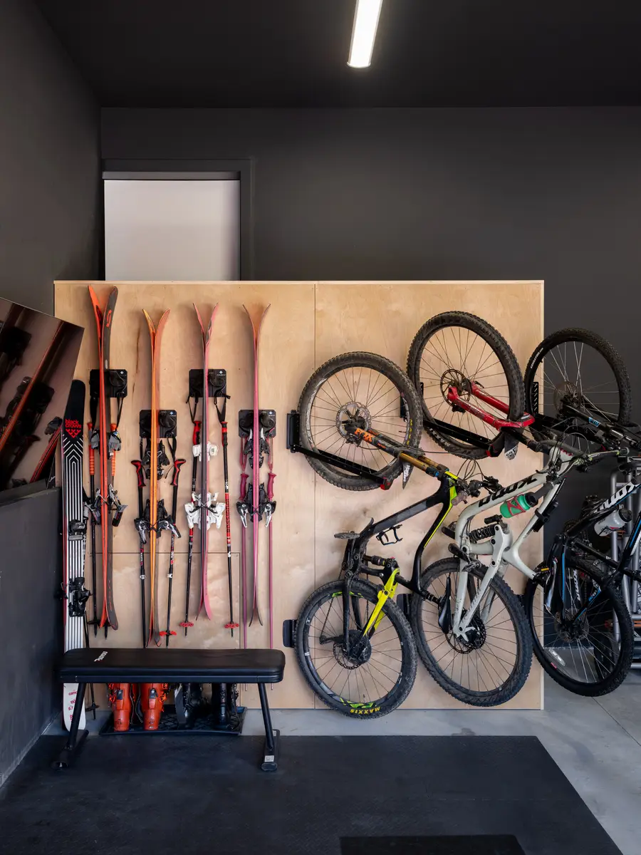 Skis and bikes hung on a plywood wall at Riverrun Place, Whistler