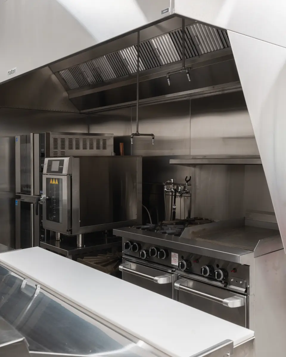 The commercial kitchen, a hood over the cooking line