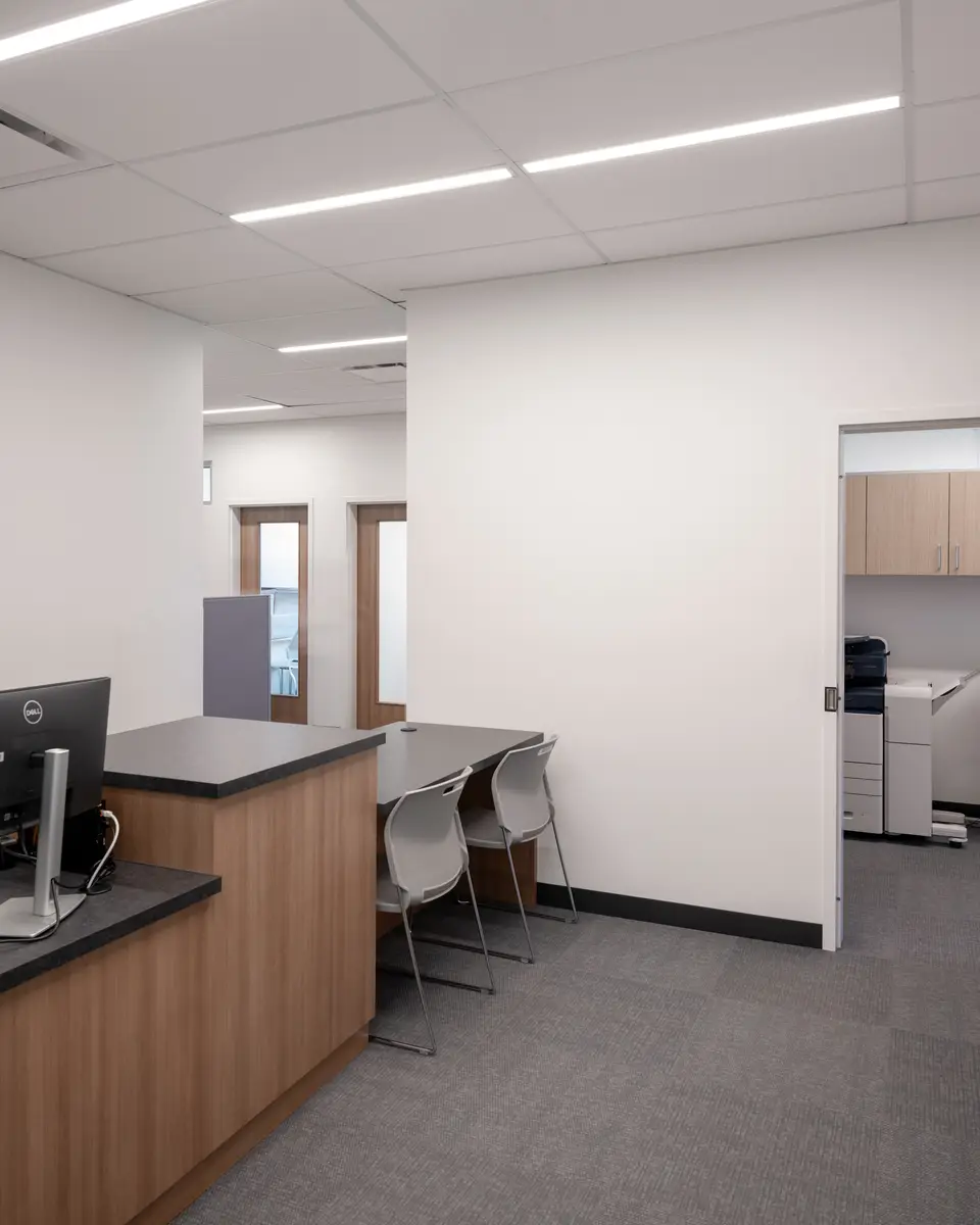 An office counter with chairs, a glass wall behind